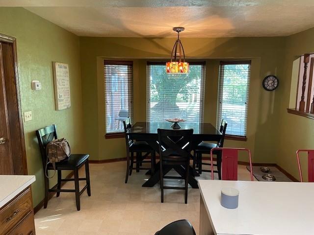 dining area with a notable chandelier and a textured ceiling