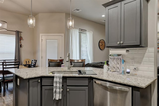 kitchen featuring decorative light fixtures, stainless steel dishwasher, and gray cabinetry