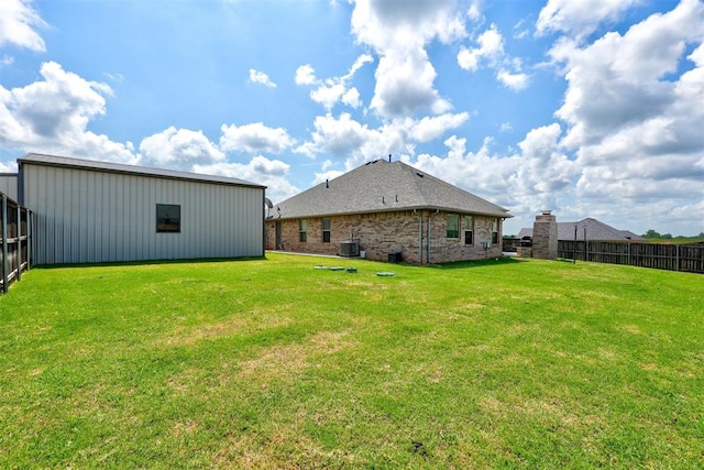 view of yard featuring central AC unit and an outdoor structure