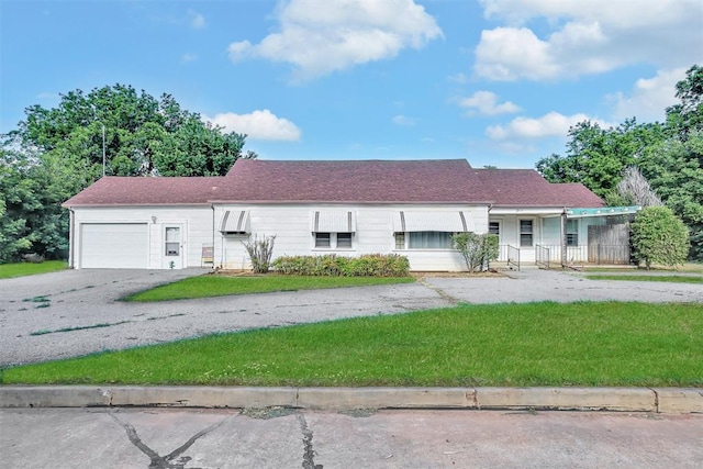 single story home featuring a front lawn and a garage