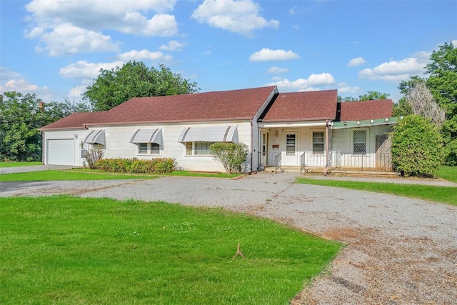 single story home featuring a porch, a garage, and a front yard