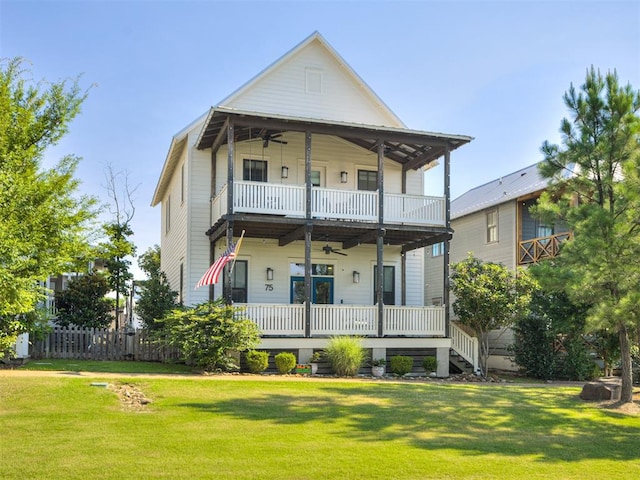 rear view of house featuring ceiling fan, a yard, and a porch