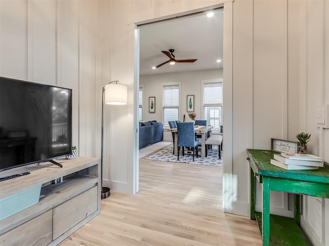 living room featuring ceiling fan and light hardwood / wood-style flooring