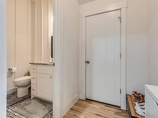 bathroom featuring wood-type flooring, vanity, and toilet