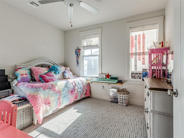 bedroom featuring ceiling fan, light carpet, and multiple windows