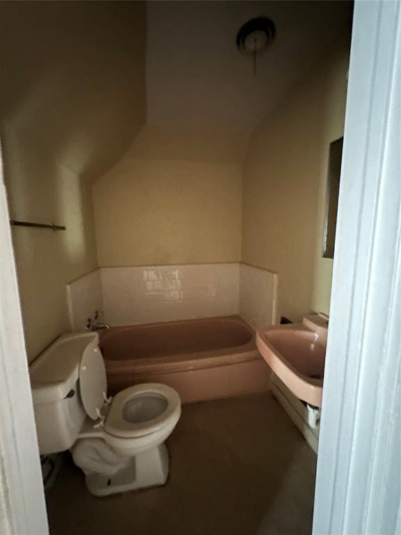 bathroom featuring a tub and toilet