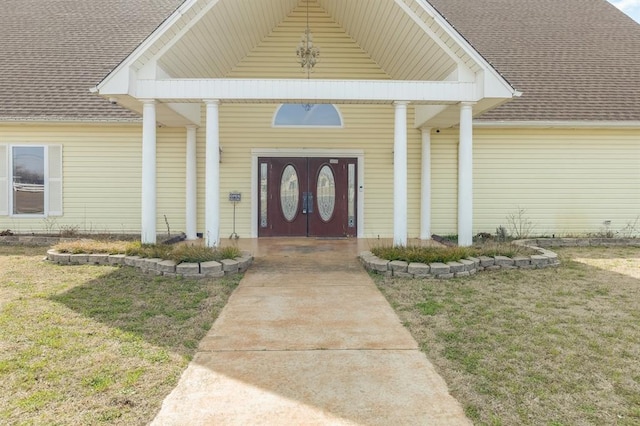 entrance to property featuring a lawn