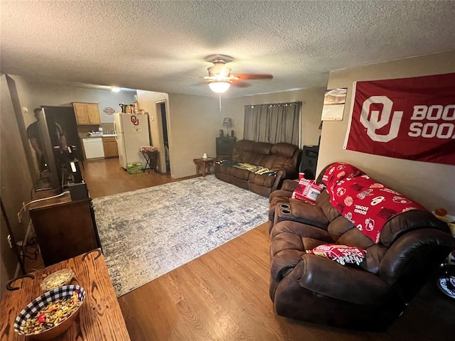 living room featuring hardwood / wood-style floors, a textured ceiling, and ceiling fan