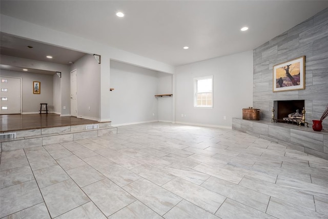 unfurnished living room with a tile fireplace