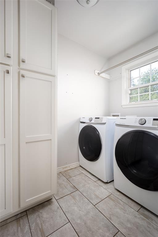 washroom featuring cabinets, washer and dryer, and light tile patterned flooring