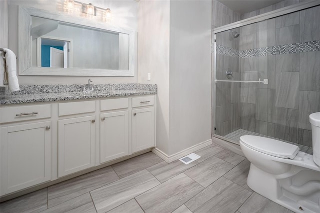 bathroom featuring walk in shower, vanity, and toilet