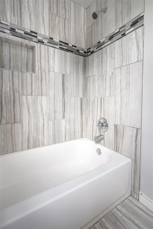 bathroom featuring tiled shower / bath and tile walls