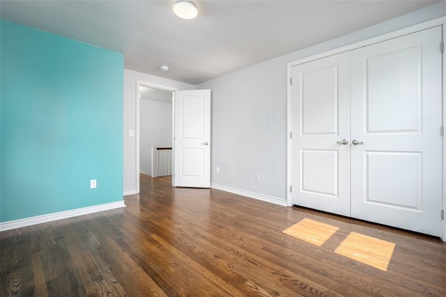 unfurnished bedroom featuring dark hardwood / wood-style flooring and a closet