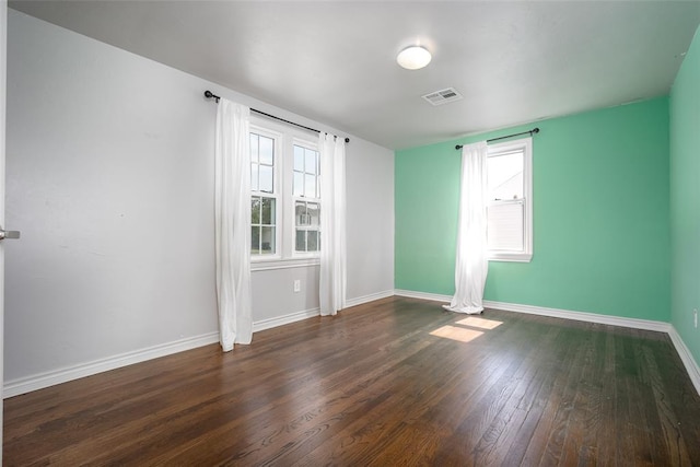 unfurnished room with dark hardwood / wood-style flooring