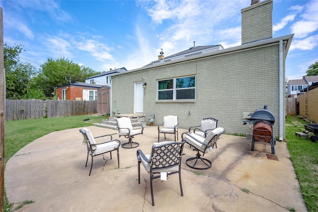 back of house featuring a lawn, a storage unit, and a patio