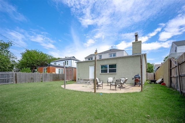 back of property with a lawn, a patio, and a storage shed