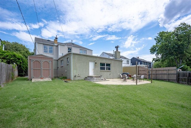 back of house featuring a lawn, a patio area, and a shed