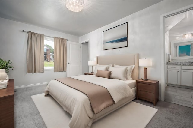 bedroom with ensuite bath, light colored carpet, and an inviting chandelier