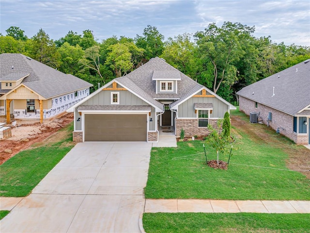 craftsman-style house featuring central air condition unit and a front lawn