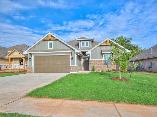 craftsman-style home with a front yard, a garage, and central AC unit