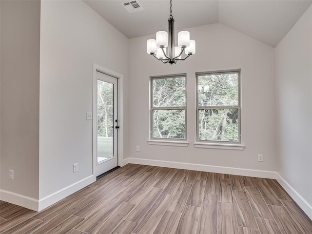 unfurnished room with plenty of natural light, light hardwood / wood-style floors, lofted ceiling, and a notable chandelier