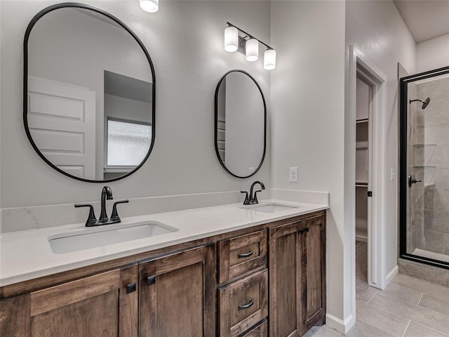 bathroom with tile patterned floors, a shower with door, and vanity