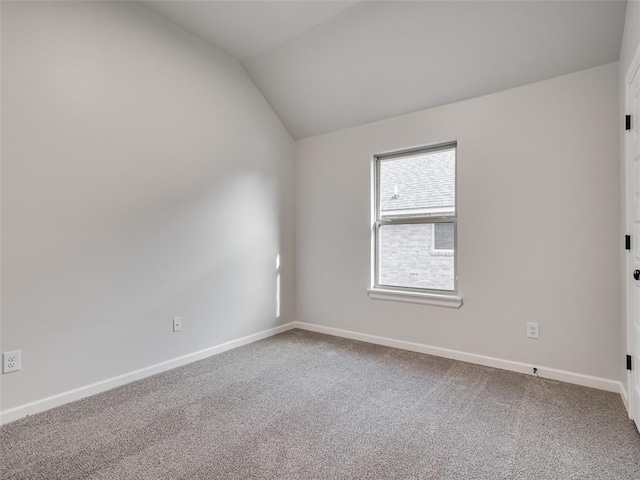 empty room featuring carpet and lofted ceiling