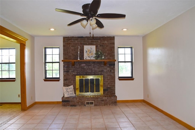 unfurnished living room featuring a fireplace, ceiling fan, plenty of natural light, and light tile patterned floors