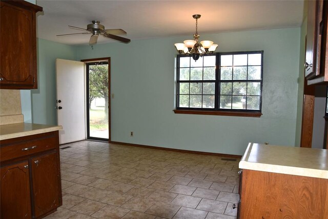 kitchen featuring ceiling fan with notable chandelier, a healthy amount of sunlight, and decorative light fixtures