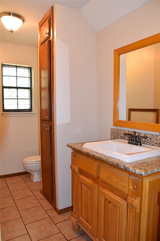 bathroom featuring tile patterned flooring, vanity, and toilet