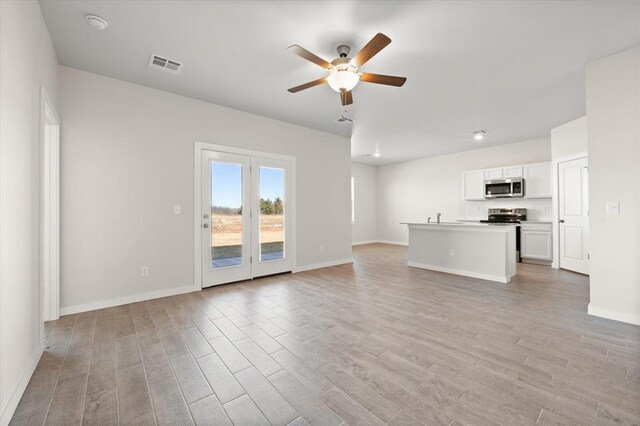 unfurnished living room with ceiling fan