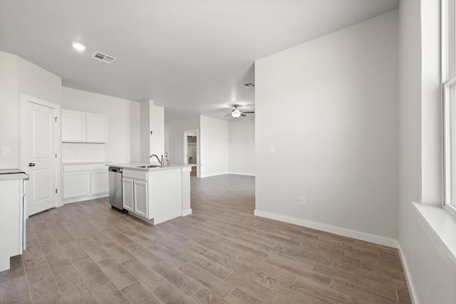 kitchen featuring white cabinetry, dishwasher, ceiling fan, a center island with sink, and light hardwood / wood-style flooring