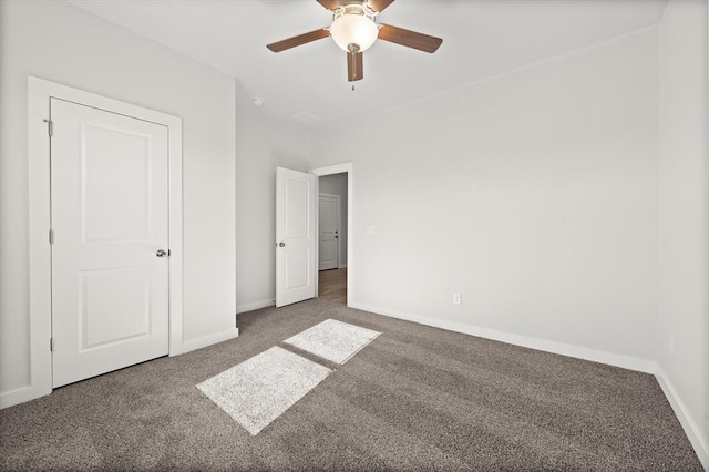 unfurnished bedroom featuring ceiling fan and dark carpet