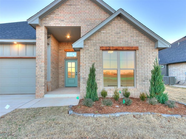 view of front of property featuring a garage and central AC