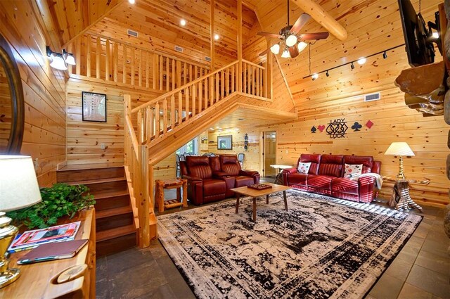 tiled living room featuring beam ceiling, high vaulted ceiling, and wooden walls