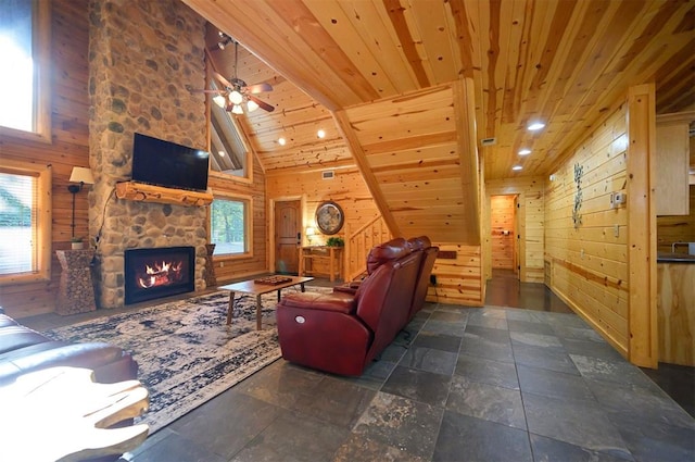 living room featuring wooden walls, high vaulted ceiling, and a wealth of natural light