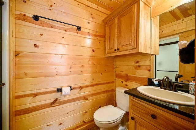 bathroom with vanity, toilet, wood ceiling, and wooden walls