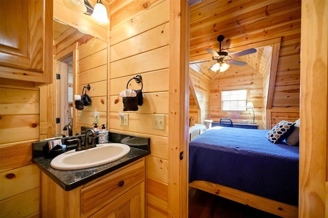 bathroom featuring wood walls, vanity, lofted ceiling, and ceiling fan