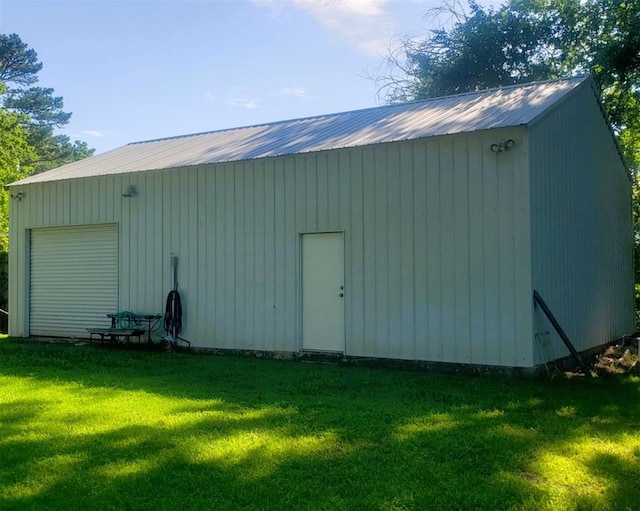 view of outdoor structure featuring a garage and a lawn