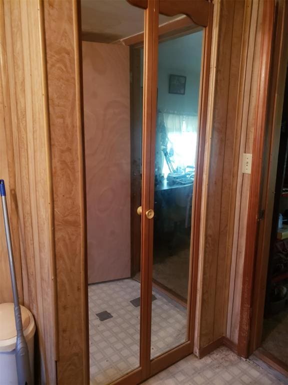 bathroom with toilet and wood walls