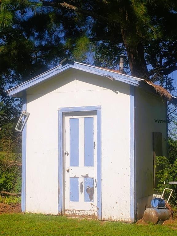 view of outbuilding featuring a lawn