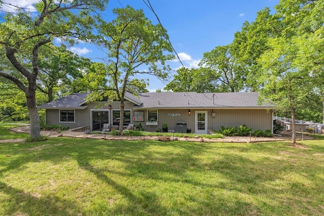 rear view of house featuring a lawn, a sunroom, and cooling unit