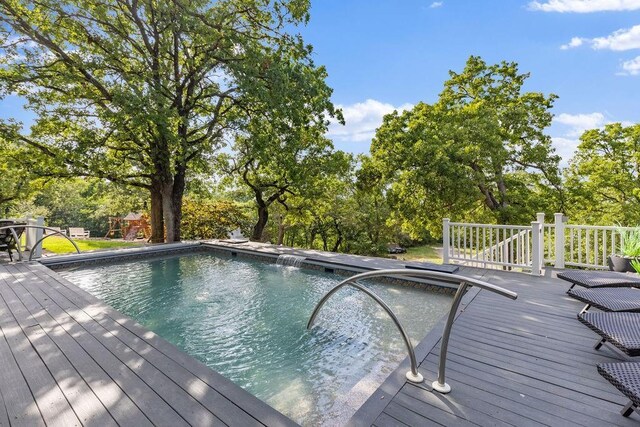 4545 Chickasaw Trl, Sulphur, OK 73086 - deck featuring an outdoor pool and view of wooded area