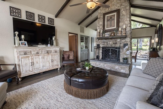 living room with dark hardwood / wood-style flooring, ceiling fan, high vaulted ceiling, beamed ceiling, and a stone fireplace