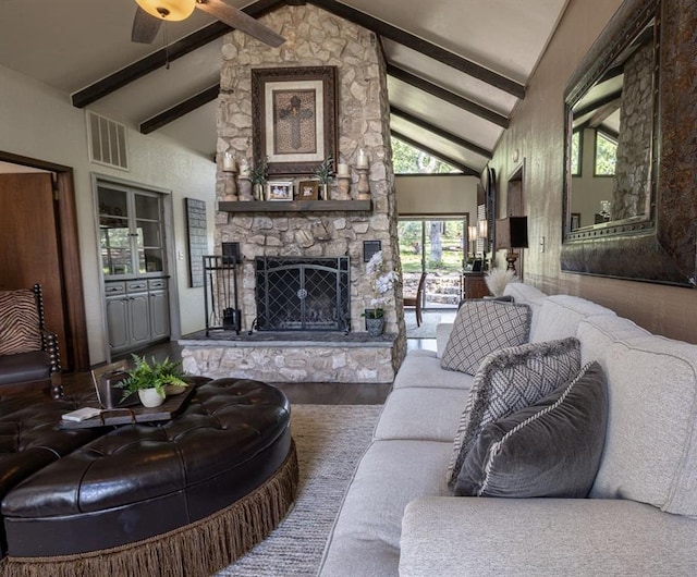 living room featuring hardwood / wood-style floors, vaulted ceiling with beams, ceiling fan, and a fireplace