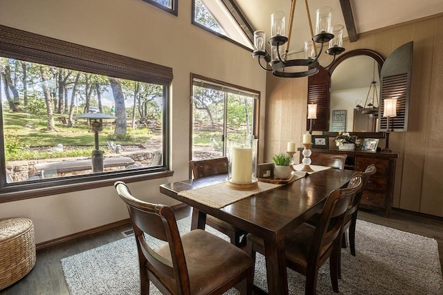 dining room with dark hardwood / wood-style flooring, vaulted ceiling with beams, and a notable chandelier