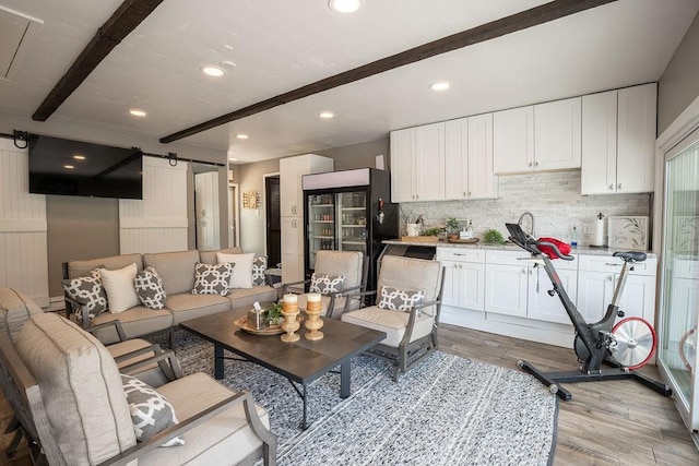 living room with light hardwood / wood-style flooring and beamed ceiling