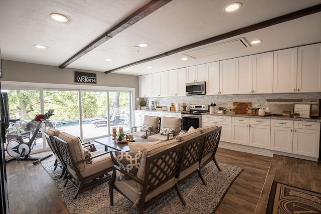 kitchen with white cabinets, dark hardwood / wood-style flooring, stainless steel appliances, and beamed ceiling