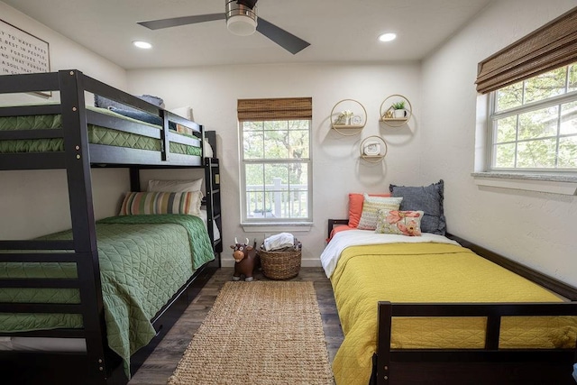 bedroom with multiple windows, dark wood-type flooring, and ceiling fan