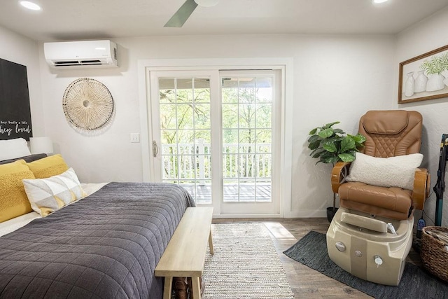 bedroom with access to exterior, hardwood / wood-style floors, a wall mounted AC, and ceiling fan